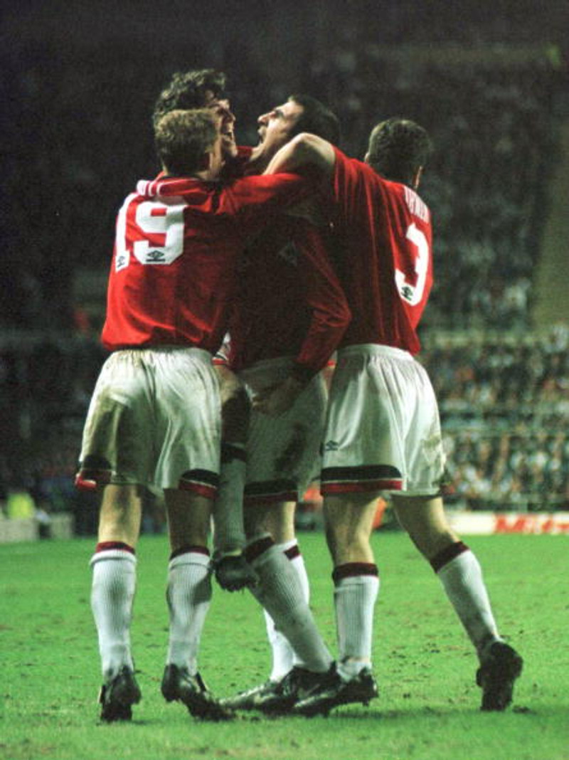Leikmenn Manchester United fagna marki Cantona í toppslagnum.