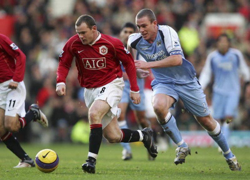 Richard Dunne eltir Wayne Rooney.