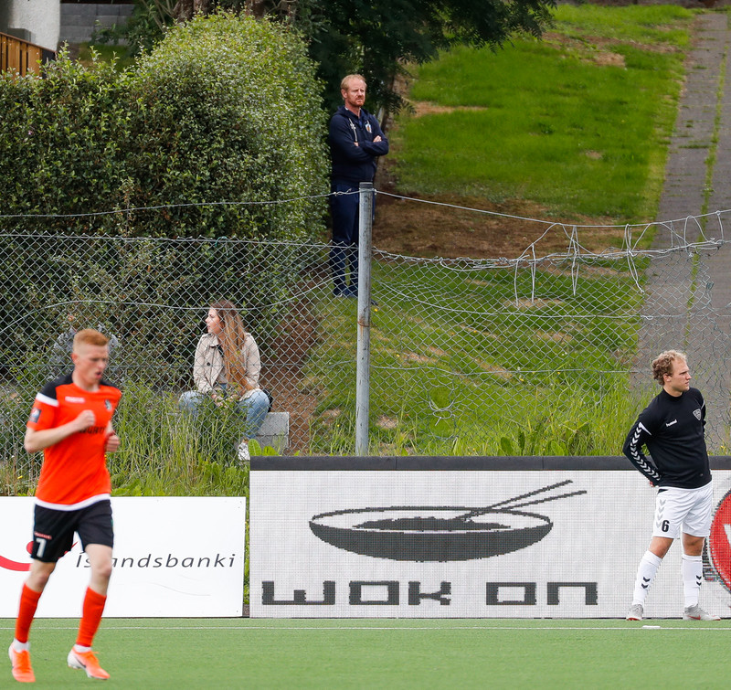 Jón Þórir Sveinsson þjálfari Fram fylgist með leik Fylkis og ÍBV úr garðinum heima hjá sér í Árbænum.