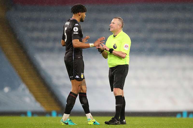 Tyrone Mings ræðir við Jon Moss, dómara.