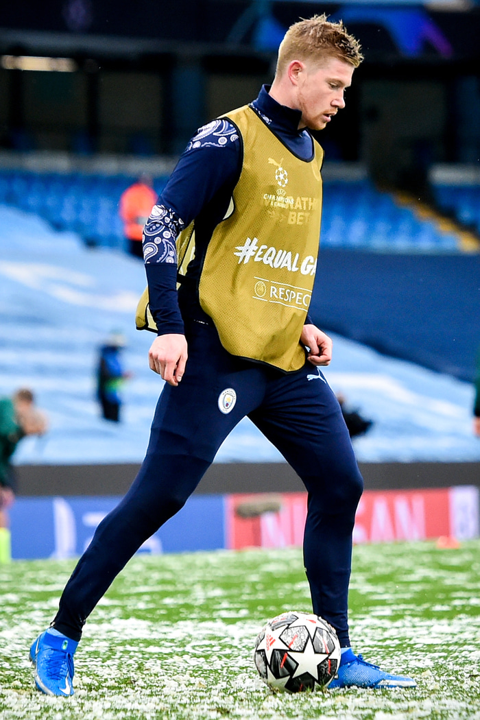 Snjór á vellinum. De Bruyne hitar upp.