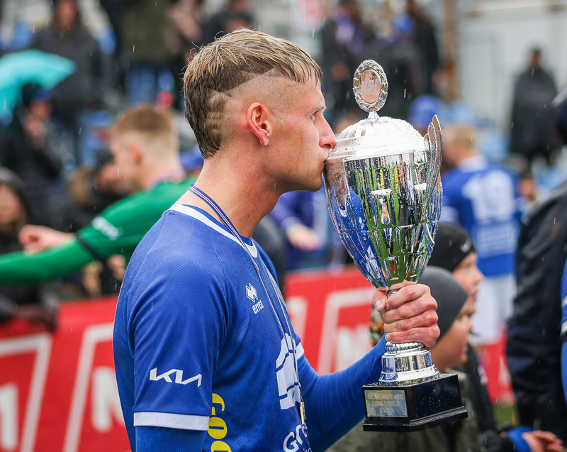 Alex Freyr kyssir bikarinns em Fram fékk fyrir sigur í Lengjudeildinni í sumar. Hann verður áfram með félaginu í efstu deild.