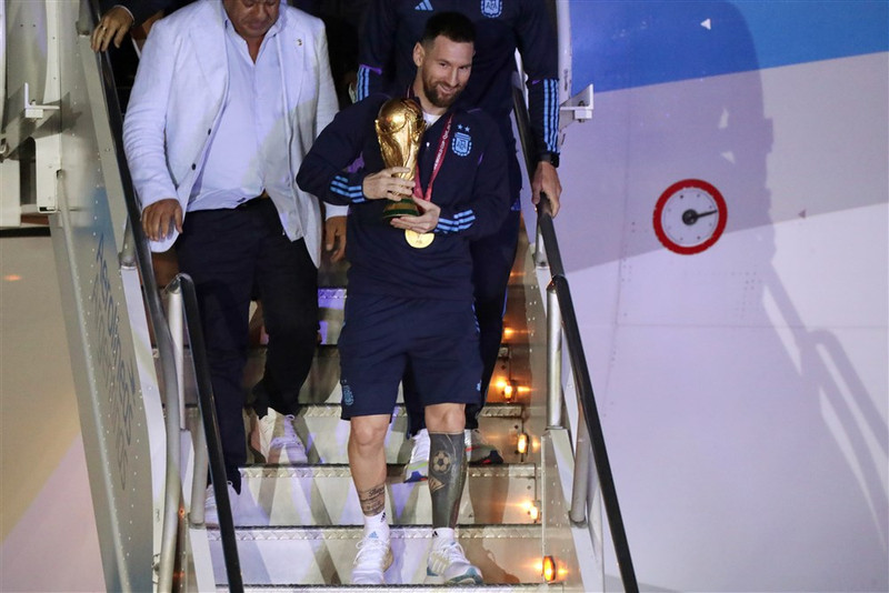 Messi gengur með bikarinn frá borði.