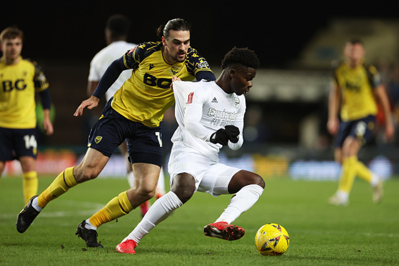 Ciaron Brown, leikmaður Oxford, heldur í Bukayo Saka.