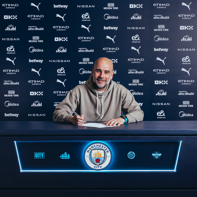Pep Guardiola skrifar undir samninginn