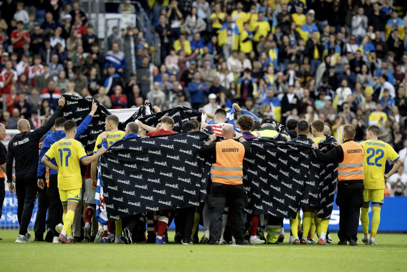 Teppi lagt yfir Eriksen eftir að hann hneig til jarðar í síðasta mánuði.