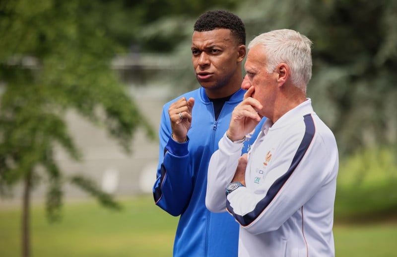 Mbappe og Didier Deschamps fara yfir málin.
